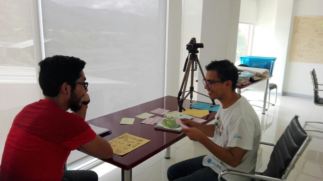 Dos personas simulan en una mesa con tarjetas la compra entre un consumidor y el camarero (futuro chatbot)
